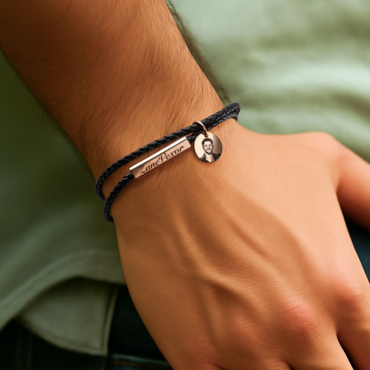 A man wears the braided bracelet with his name and photo engraved on it.