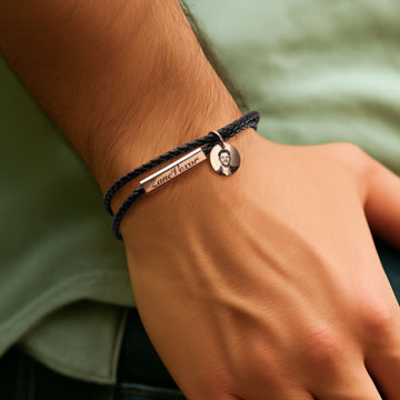 A man wears the braided bracelet with his name and photo engraved on it.