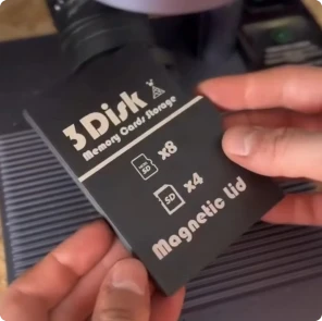 Un maker usa una LaserPecker LP4 para grabar un logotipo personalizado en una caja negra para tarjetas SD, impresa en PLA en 3D.