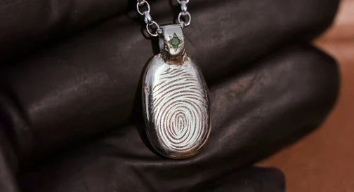 Custom metal pendal featuring a fingerprint.