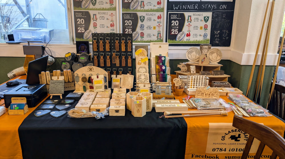Plusieurs objets en bois gravés sont exposés sur une table.
