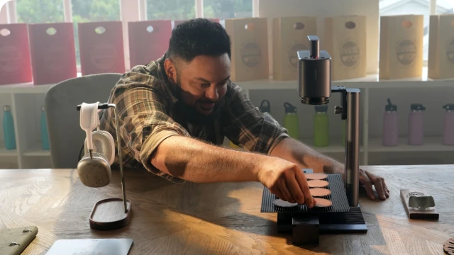 A creator using the LaserPecker LP2 Plus to "Mark Your Business with Precision," creating professional office nameplates and branding materials.