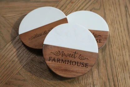 LaserPecker LP2 Plus high-precision engraving on circular wooden coasters, showcasing sharp script fonts and uniform "Sweet Farmhouse" branding on solid wood.
