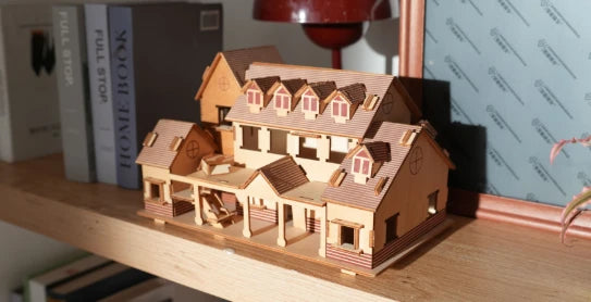 A highly detailed 3D wooden house model assembled from precision-cut pieces, showcasing the high-resolution architectural modeling capabilities of the LP2 Plus.