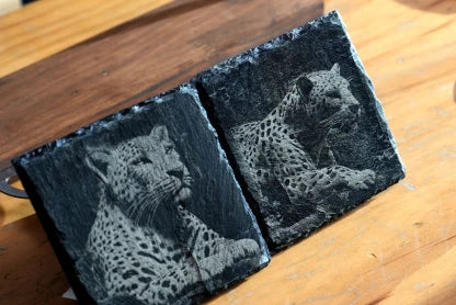 LaserPecker LP2 Plus engraving on square slate coasters, featuring high-detail photographic portraits of leopards with realistic fur texture and high contrast.