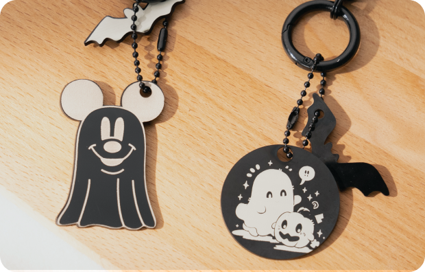 Deux porte-clés en bois gravés avec des motifs d’Halloween.