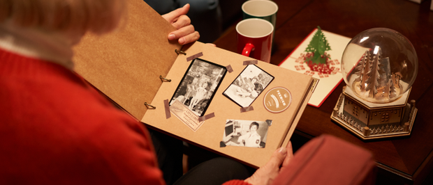 Des personnes regardant un album photo fait main dans une ambiance de Noël.