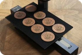 LaserPecker LP2 Plus with Slide Extension accessory, performing high-speed batch engraving on a series of circular leather coasters with consistent precision.